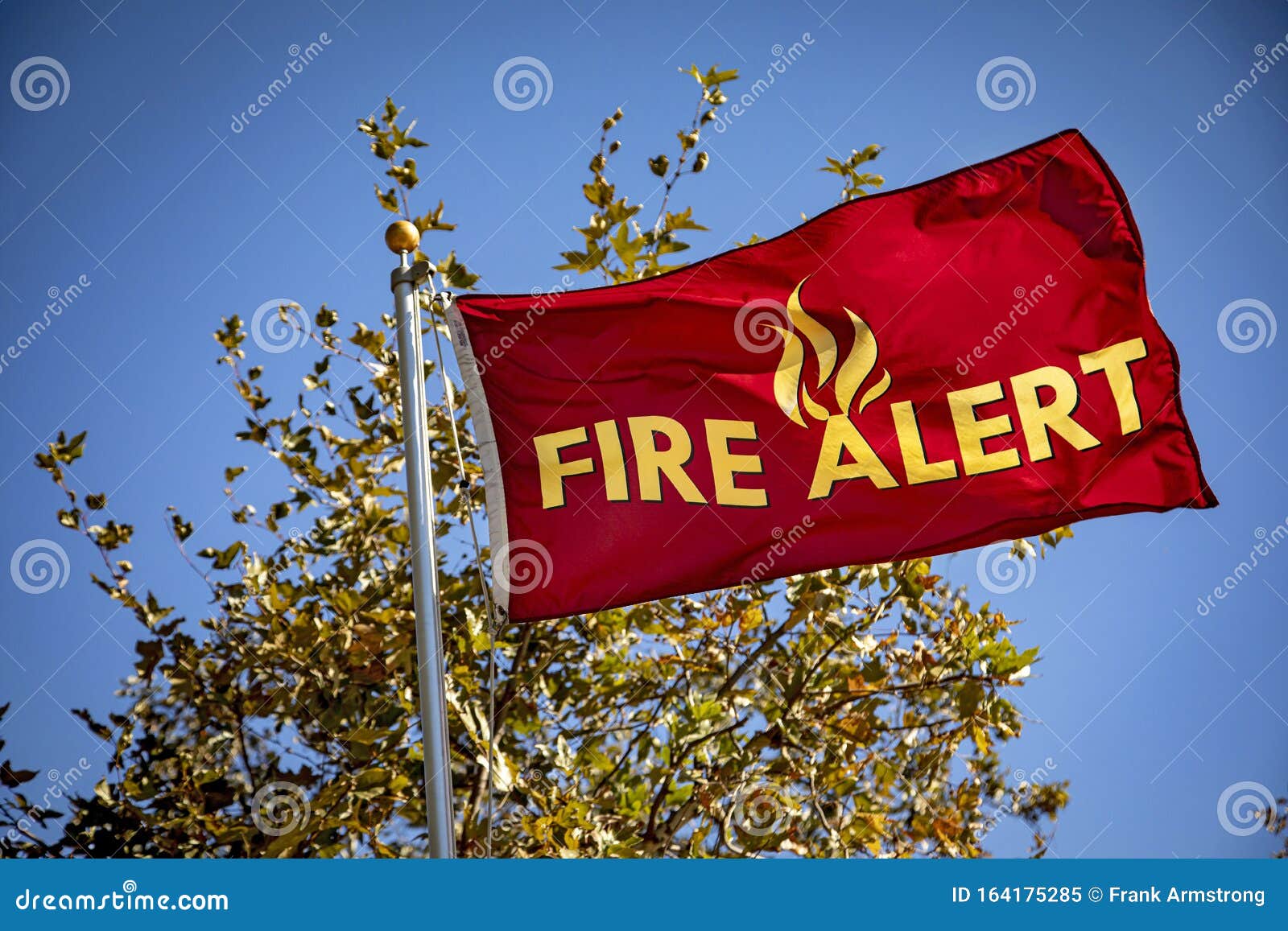 red flag in wind with yellow letters reading `fire alert`